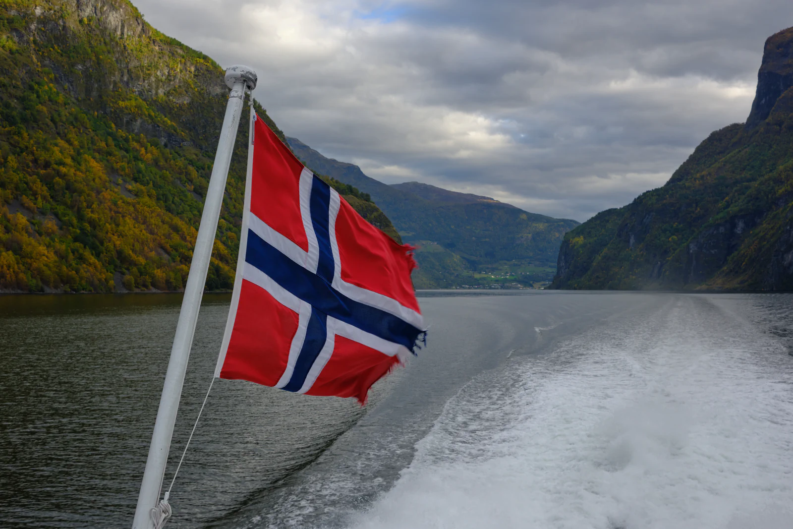 Norwegian flag on the stern of a ferry in a fjord